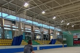 Operari polint el parquet de la pista interior d’un pavelló esportiu