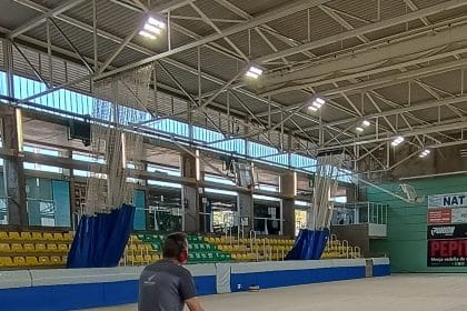 Operari polint el parquet de la pista interior d’un pavelló esportiu